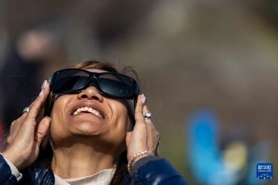 4月8日，一名女子在美國(guó)紐約州普拉茨堡觀看日食。新華社發(fā)（文森特·約翰遜攝）