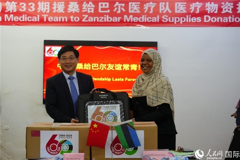 江蘇省蘇北人民醫(yī)院黨委書記束余聲捐贈物資與桑衛(wèi)生部首席秘書哈比巴。中國援桑醫(yī)療隊(duì)供圖