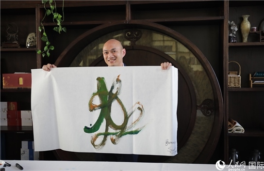 老撾駐華大使館三秘明君參加《五百筆·瀾湄合作》集體藝術(shù)創(chuàng)作。人民網(wǎng)王婧攝。