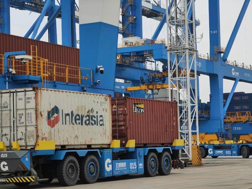 在欽州自動(dòng)化集裝箱碼頭，智能導(dǎo)引運(yùn)輸車在運(yùn)送集裝箱。新華社記者趙歡 攝