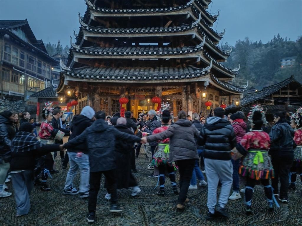 法國青年與當(dāng)?shù)卮迕駹渴痔?。新華社記者 羅羽 攝