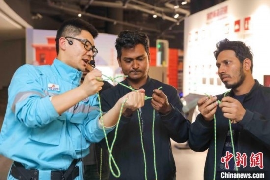 5月9日，工作人員指導(dǎo)留學(xué)生學(xué)習(xí)打繩結(jié)。張鷹 攝