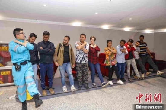 5月9日，工作人員指導(dǎo)留學(xué)生練習(xí)逃生技巧。張鷹 攝