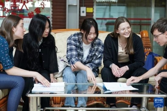 4月28日，宋智孝（右二）和胡靈月（左一）在北京首都師范大學(xué)校園內(nèi)與同學(xué)交流。新華社記者 彭子洋 攝