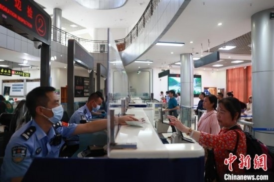 圖為旅客在磨憨口岸辦理通關(guān)手續(xù)。雷雨 攝