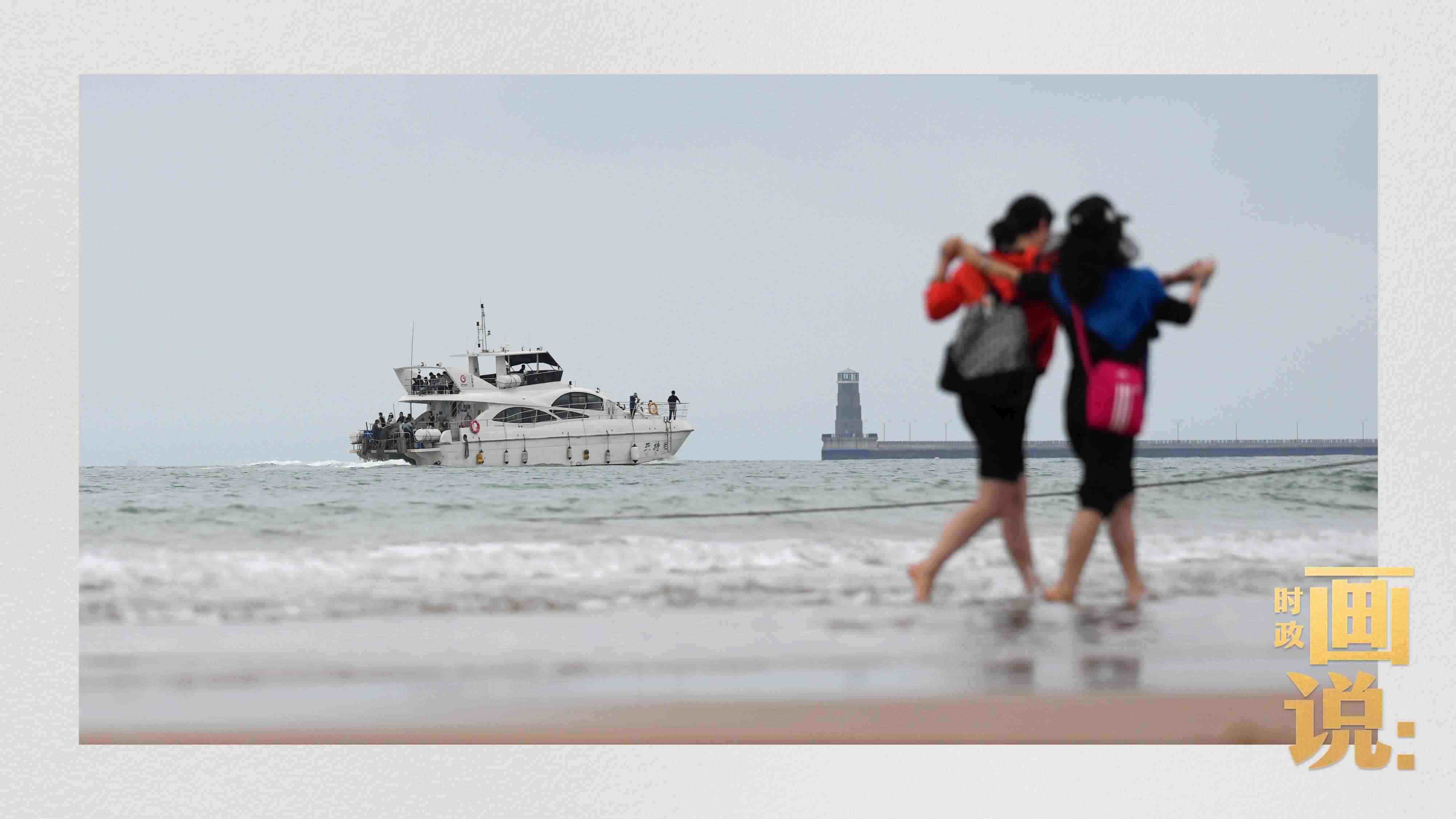 △日照陽(yáng)光海岸綠道上的萬(wàn)平口景區(qū)，一對(duì)游客在海浪中翩然起舞。