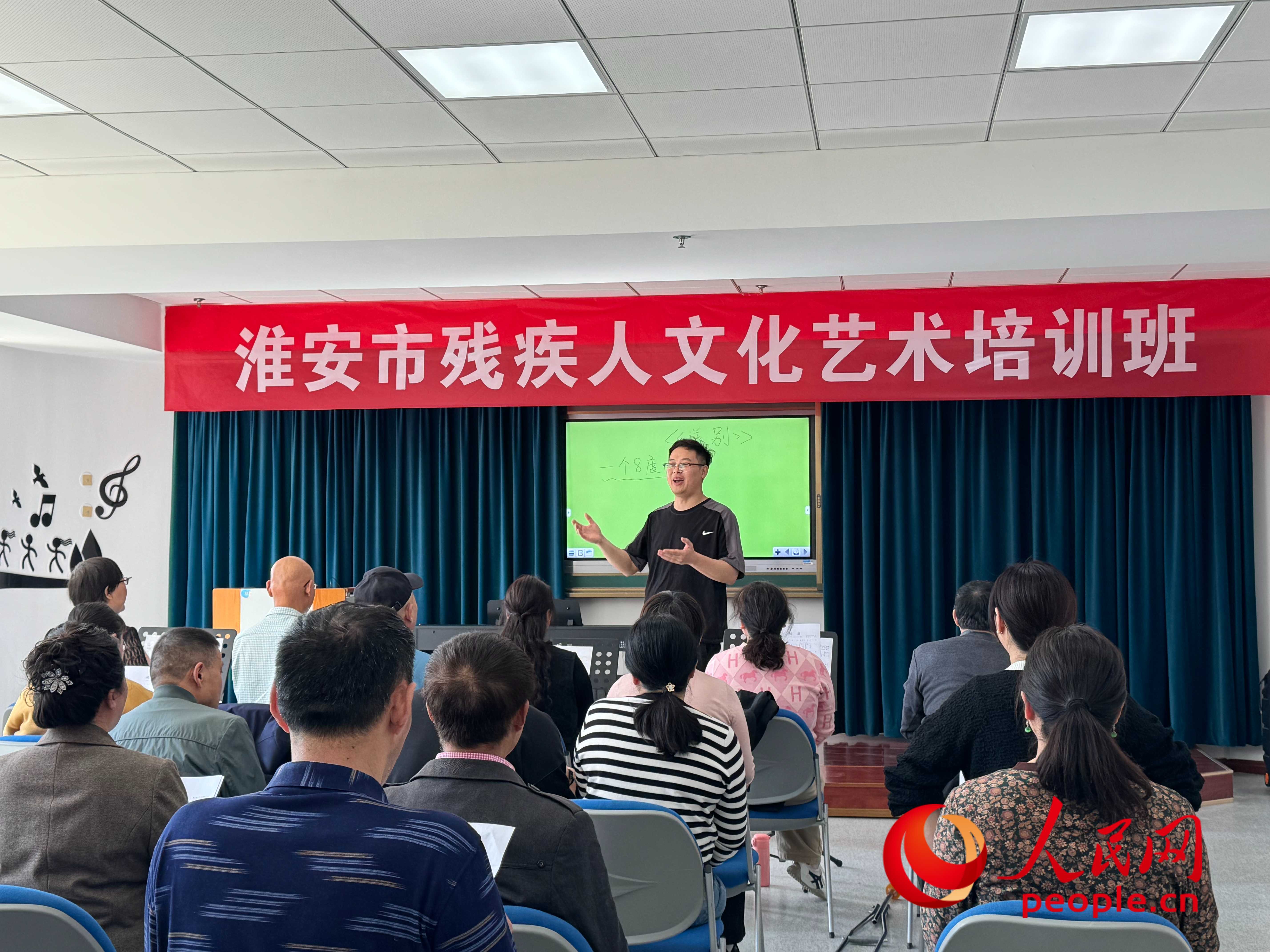 在淮安市殘疾人文化藝術(shù)培訓(xùn)班上，聲樂老師在教殘疾人唱《送別》這首歌曲。人民網(wǎng) 周靜圓攝