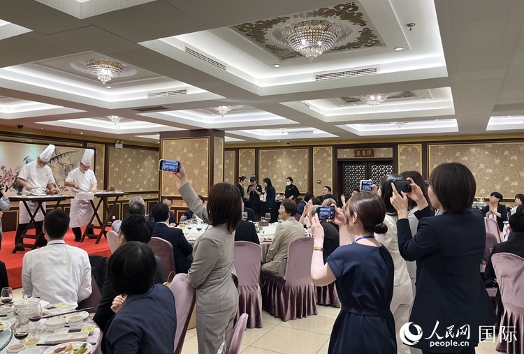 國家級非物質(zhì)文化遺產(chǎn)、全聚德片鴨工藝吸引代表團(tuán)成員拍照留念。