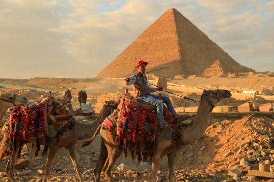 1月24日，商販騎駱駝離開埃及吉薩金字塔景區(qū)。新華社記者 隋先凱 攝
