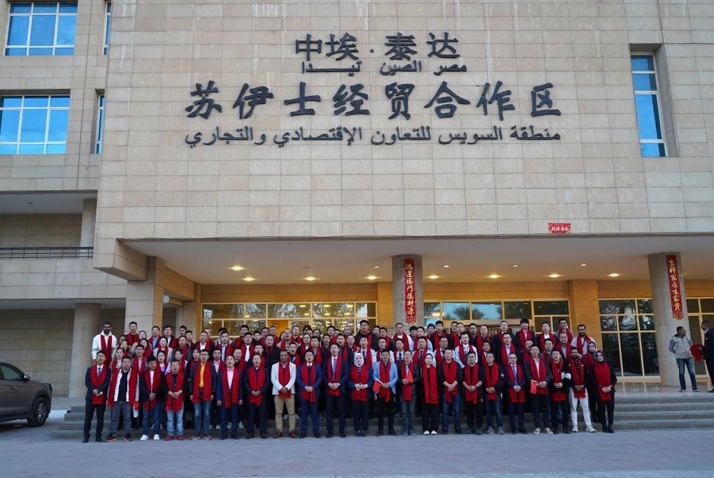 2024年2月11日，在位于埃及蘇伊士省的中?！ぬ┻_蘇伊士經(jīng)貿(mào)合作區(qū)，中埃員工在合作區(qū)辦公大樓前合影拜年。新華社發(fā)（泰達合作區(qū)供圖）
