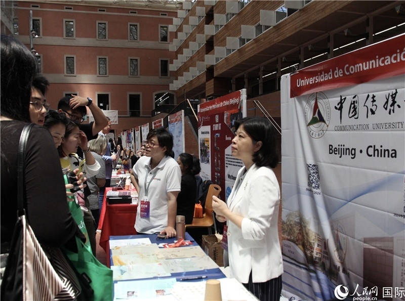 旅西華人華僑在展臺前咨詢。人民網(wǎng)記者 許海林?jǐn)z