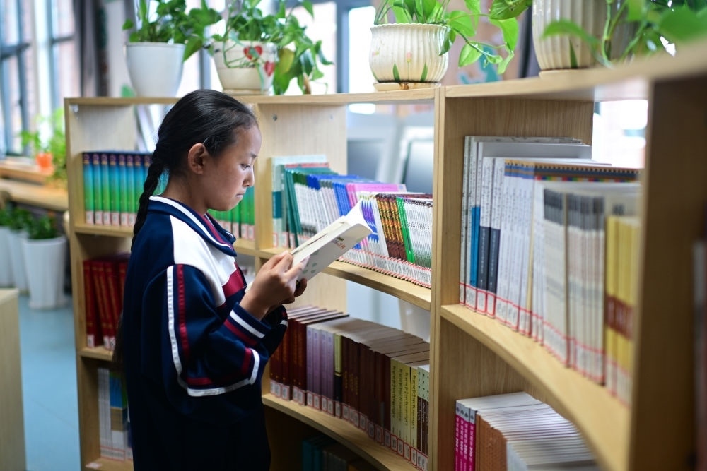 6月18日，果洛西寧民族中學(xué)學(xué)生尼東拉毛在圖書(shū)室看書(shū)。