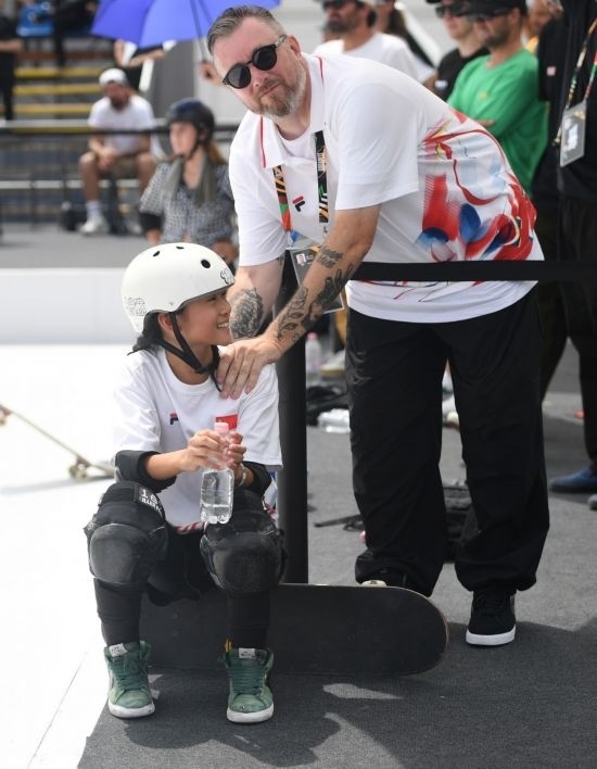 6月20日，鄭好好（左）在比賽間隙與教練互動，她在預(yù)賽中最佳成績?yōu)?2.60分。當(dāng)日，巴黎奧運會資格系列賽布達佩斯站滑板女子碗池預(yù)賽在布達佩斯舉行。新華社記者 賀燦鈴 攝