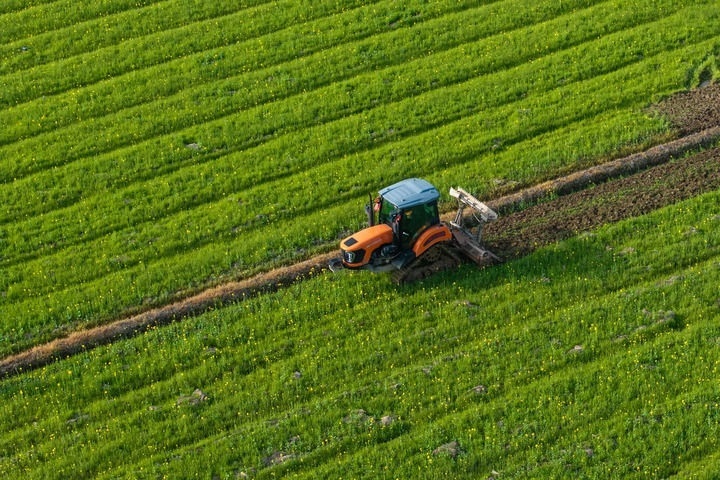 2024年3月19日，在湖南省常德市鼎城區(qū)謝家鋪鎮(zhèn)港中坪村，村民駕駛農(nóng)機翻耕田地（無人機照片）。新華社記者 陳思汗 攝