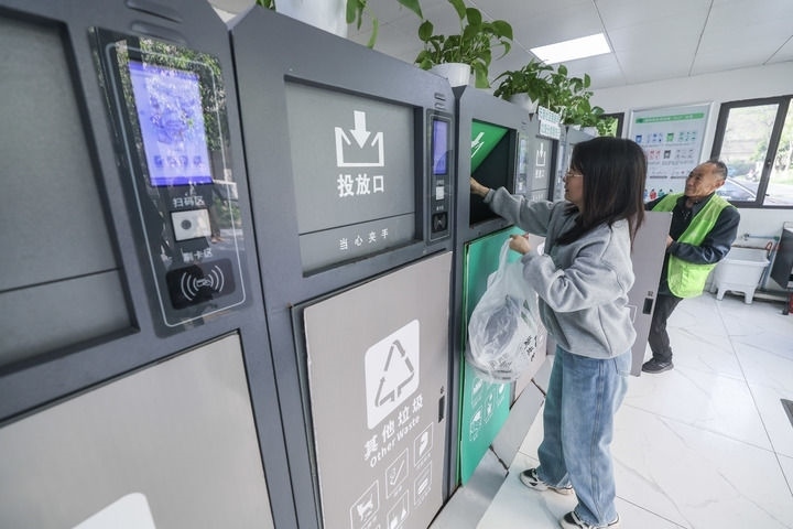 2024年4月10日，在浙江省湖州市吳興區(qū)飛英街道新華府小區(qū)內(nèi)，居民在垃圾分類智能系統(tǒng)的指導下進行垃圾分類投放，居民的投放情況將實時匯總到智慧服務(wù)平臺，會有相應(yīng)的積分獎勵。新華社記者 徐昱 攝