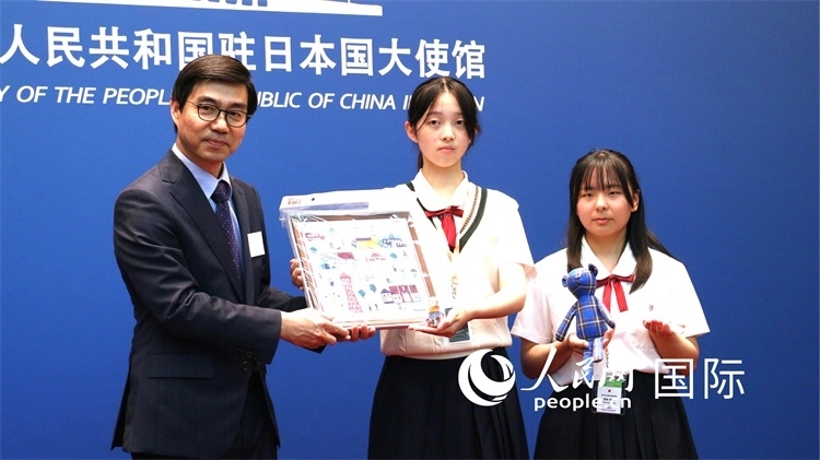 日本小大使向中國駐日本大使館臨時代辦施泳贈送當?shù)靥厣Y品。人民網(wǎng) 許可攝