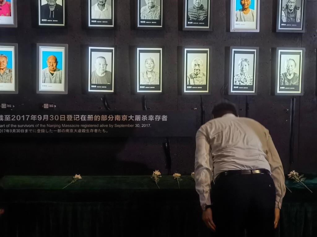 7月18日，人們向離世的南京大屠殺幸存者獻花、鞠躬。新華社記者邱冰清 攝