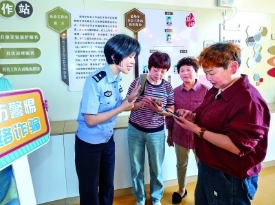 浙江湖州民警指導(dǎo)居民加入湖州“e企安”微信群，實(shí)時(shí)接收反詐信息。新華社發(fā)