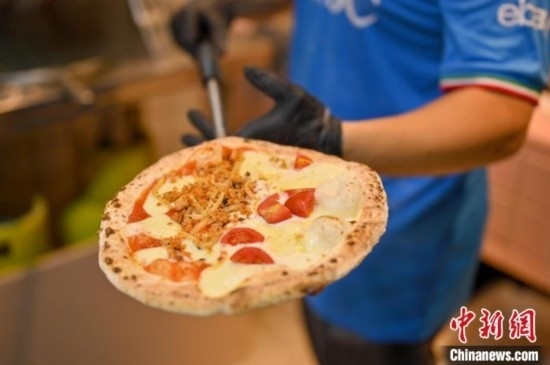 近日，韋榮耀展示他制作的“老友味”披薩。 俞靖 攝