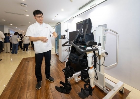 2024年5月24日，在位于上海市嘉定區(qū)的上海交通大學(xué)醫(yī)學(xué)院附屬瑞金醫(yī)院腫瘤質(zhì)子中心，工作人員介紹由瑞金醫(yī)院醫(yī)生和醫(yī)療公司共同研發(fā)的用于恢復(fù)患者下肢的醫(yī)療機器人。新華社記者 王翔 攝