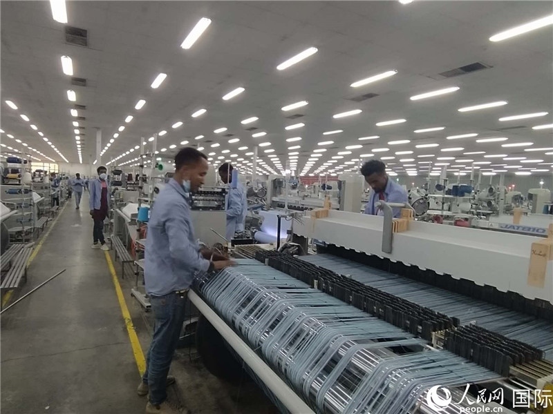 無錫金茂埃塞面料廠車間內(nèi)，當(dāng)?shù)毓と苏谝唤z不茍地作業(yè)。人民網(wǎng)記者 黃培昭攝