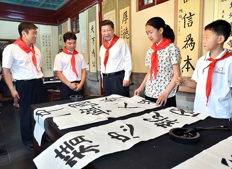2014年5月30日，習(xí)近平總書記來到北京市海淀區(qū)民族小學(xué)，參加慶?！傲弧眹H兒童節(jié)活動。這是總書記觀看學(xué)生書寫的毛筆字。