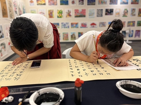 參加本次展覽的青少年在現(xiàn)場進(jìn)行書法創(chuàng)作。主辦方供圖
