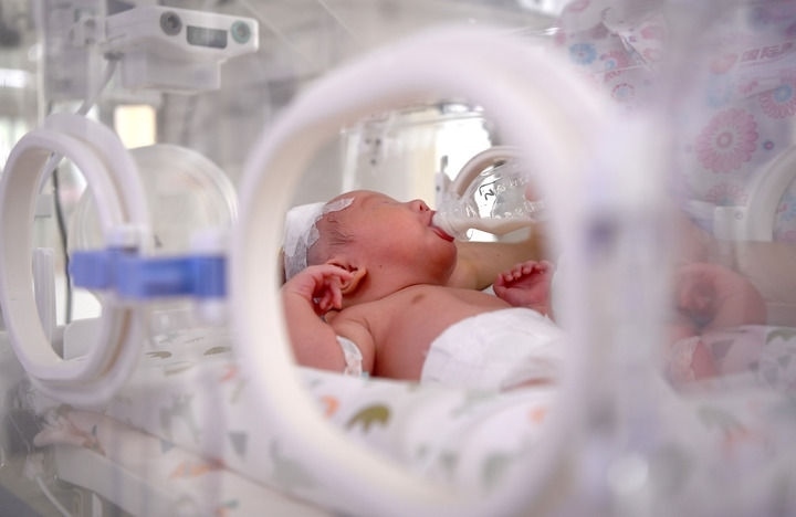 2024年6月1日，在西安國際醫(yī)學(xué)中心醫(yī)院新生兒科病房，護(hù)士為新生兒喂奶。 新華社記者 劉瀟 攝