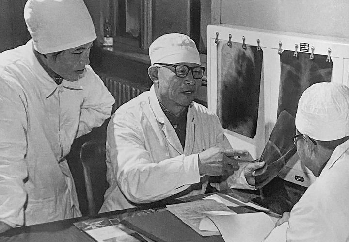 1980年1月16日，中日友好醫(yī)院首任院長辛育齡（中）在內(nèi)蒙古結(jié)核病院與胸外科醫(yī)師討論病例（翻拍照片）。 新華社發(fā)