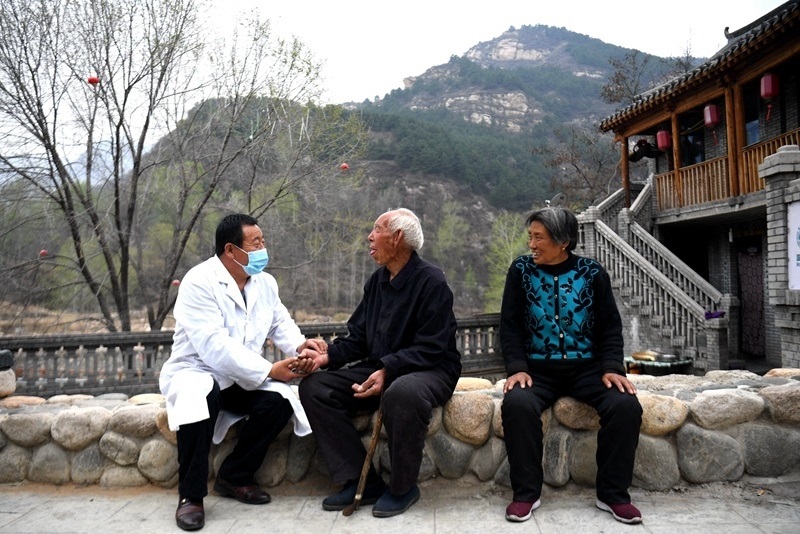 2020年4月15日，在河北阜平縣龍泉關(guān)鎮(zhèn)駱駝灣村，村醫(yī)霍建國為村民把脈。