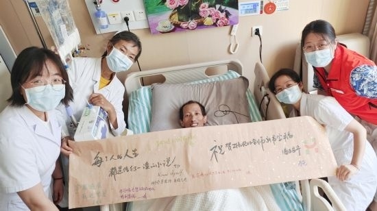 7月26日，海淀醫(yī)院安寧療護(hù)科醫(yī)護(hù)團隊為朱銳送來一條寫滿祝福的橫幅。（受訪者供圖）