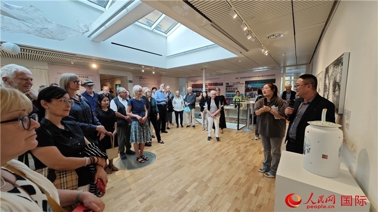 參展人、景德鎮(zhèn)陶瓷大學(xué)美術(shù)學(xué)院副院長邵長宗（右一）向來賓介紹參展作品。人民網(wǎng)記者 殷淼攝