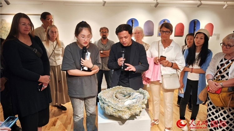 參展人、景德鎮(zhèn)陶瓷大學(xué)設(shè)計(jì)藝術(shù)學(xué)院副院長余劍峰（中）向來賓介紹參展作品。人民網(wǎng)記者 殷淼攝