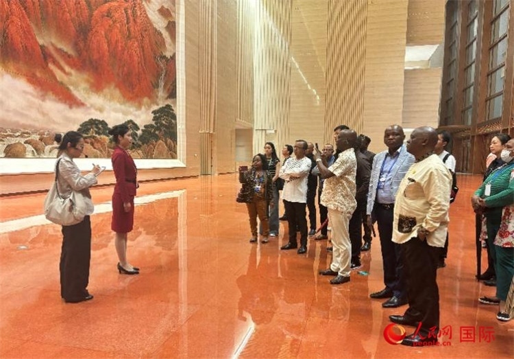 代表團在入口處聽取講解。人民網(wǎng) 曹欣悅攝