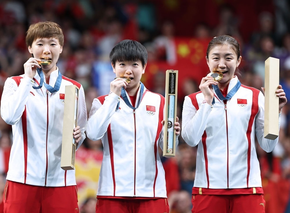 冠軍中國隊選手王曼昱、孫穎莎、陳夢（從左至右）在巴黎奧運會乒乓球女子團體頒獎儀式上（2024年8月10日攝）。新華社記者 王東震 攝