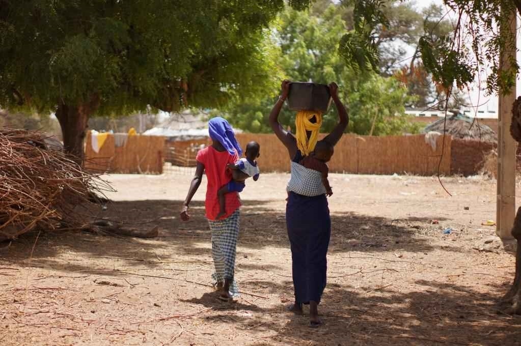 2023年3月20日，在塞內(nèi)加爾久爾貝勒區(qū)的泰內(nèi)富勒村，村民將取到的水運回家。新華社記者 王子正 攝