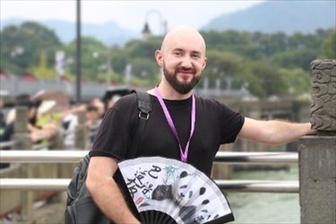 俄羅斯塔斯社執(zhí)行編輯葉夫根尼·扎多羅日內(nèi)在都江堰魚(yú)嘴拍照留念。（李佩藺 攝）