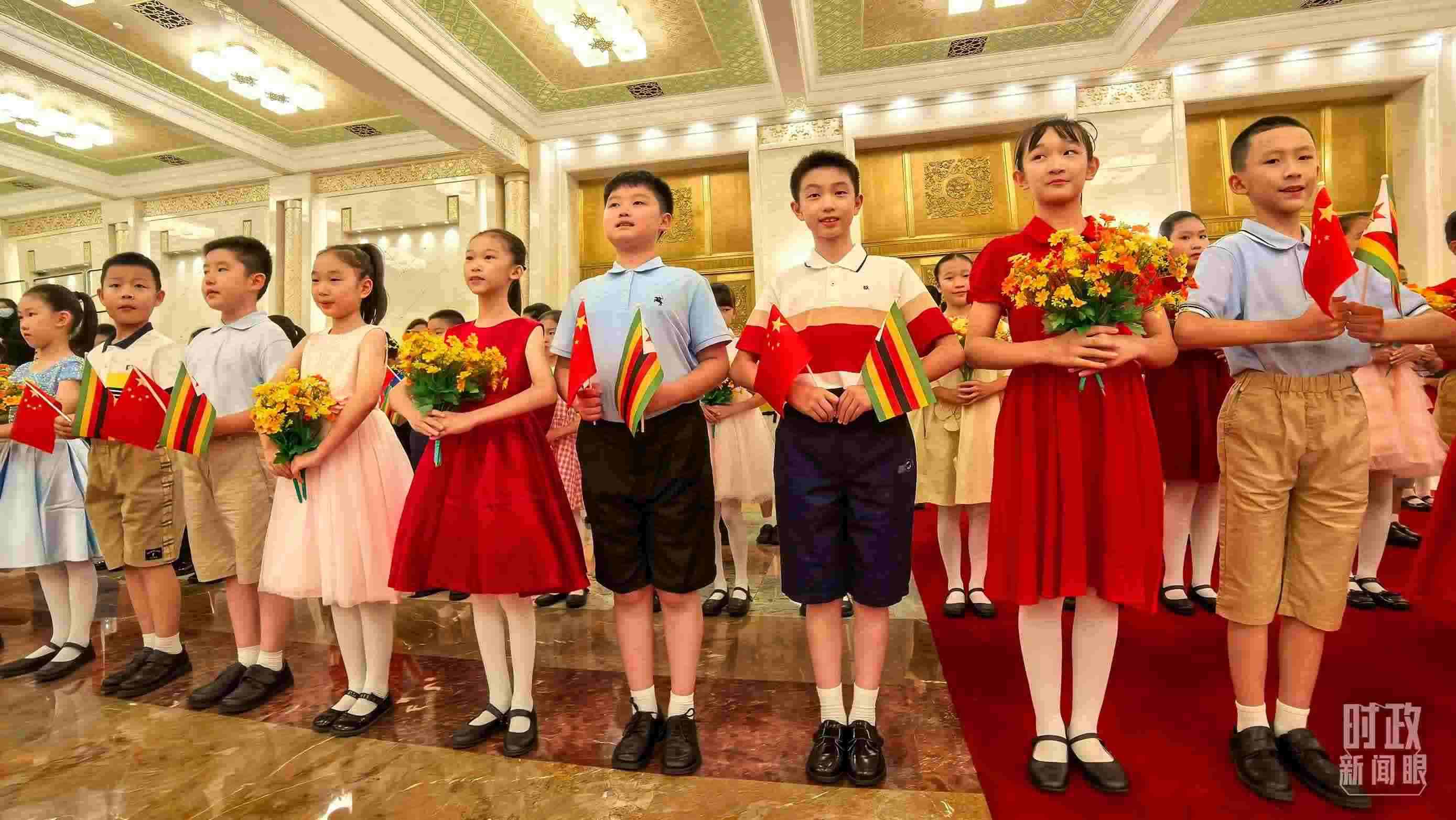 △現(xiàn)場歡迎津巴布韋總統(tǒng)訪華的青少年。（總臺央視記者鐘銳拍攝）