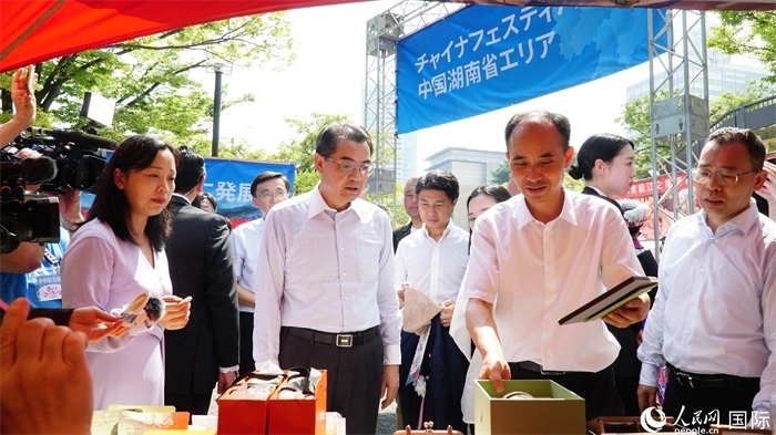 湖南展位工作人員向中國(guó)駐日本大使吳江浩介紹特色文創(chuàng)產(chǎn)品。人民網(wǎng) 蔣曉辰攝