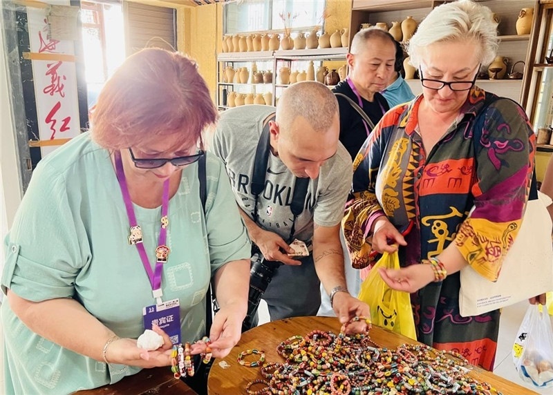 歐亞媒體考察團(tuán)成員在母氏陶藝館內(nèi)挑花了眼，色彩絢麗、質(zhì)地均勻的陶藝手串讓他們愛(ài)不釋手?！斑@里的東西都太實(shí)惠了！”塔吉克斯坦《索格特真理報(bào)》政論部主任娜塔利婭·多羅費(fèi)耶娃說(shuō)?；宓奶厣a(chǎn)品物美價(jià)廉，讓考察團(tuán)成員為家人好友買(mǎi)到了心儀的禮物，也為此次以四川成都為起點(diǎn)，路經(jīng)南充、廣安至貴州遵義的考察行程畫(huà)上了圓滿句號(hào)。（張亞欣攝）