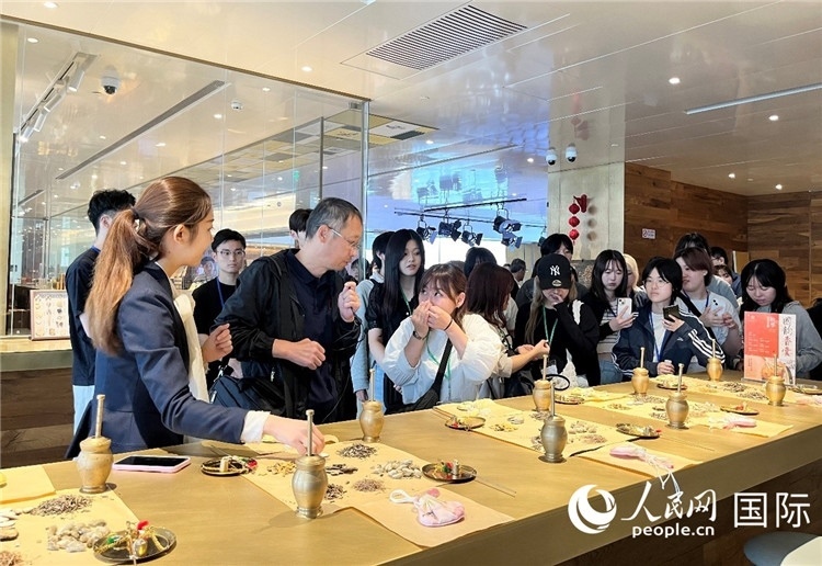 1. 日中友好協(xié)會青年代表團(tuán)一行學(xué)習(xí)中醫(yī)香囊制作工序。（人民網(wǎng)記者陳思 攝）
