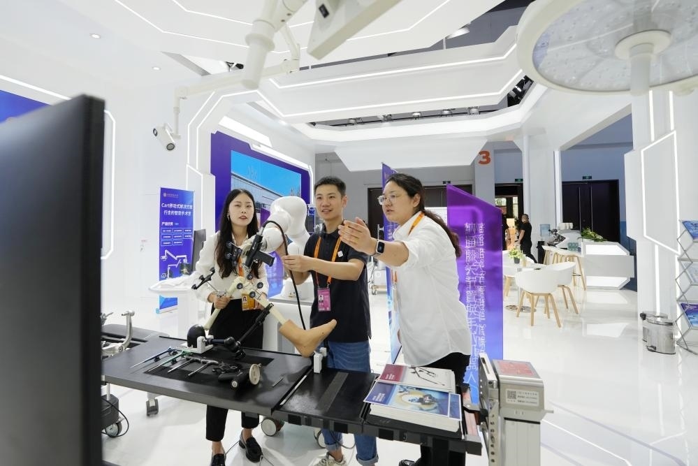 9月11日，一位媒體記者（中）在2024年服貿(mào)會(huì)國(guó)家會(huì)議中心會(huì)場(chǎng)體驗(yàn)北京納通科技集團(tuán)有限公司的膝關(guān)節(jié)置換手術(shù)機(jī)器人。新華社記者鞠煥宗 攝