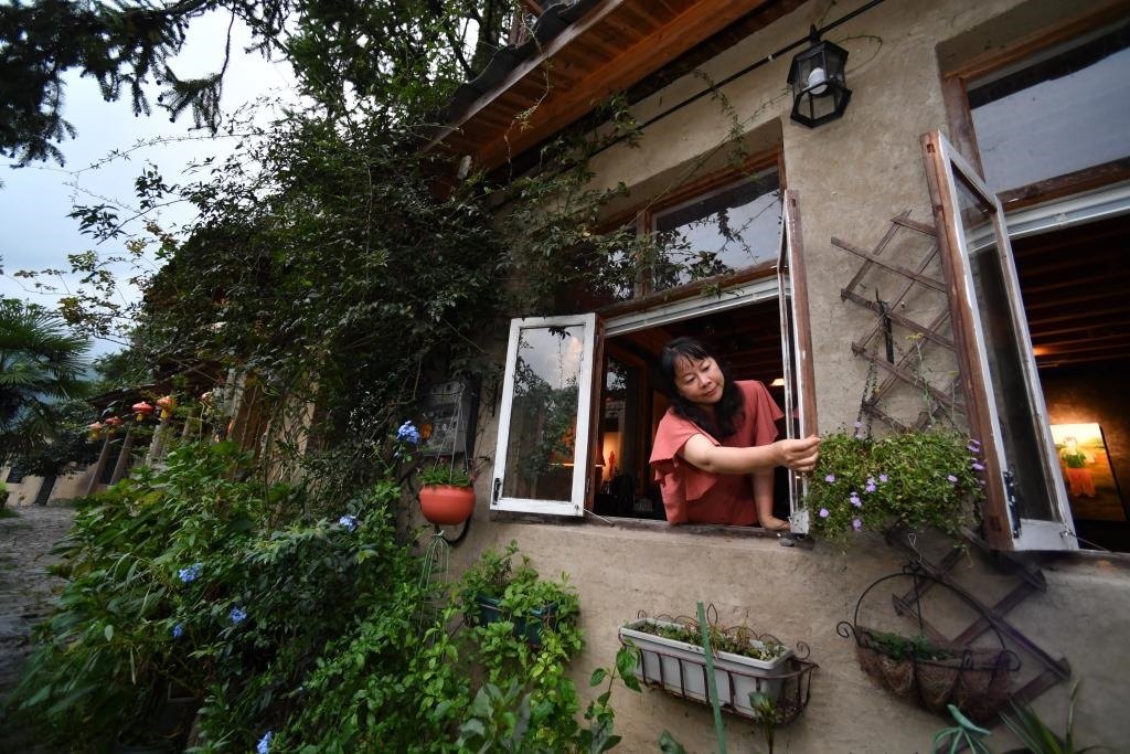 8月29日，在福建省屏南縣熙嶺鄉(xiāng)，龍?zhí)洞濉靶麓迕瘛泵泛暝诖蚶碜约航?jīng)營的民宿外墻裝飾花盆。新華社記者姜克紅 攝