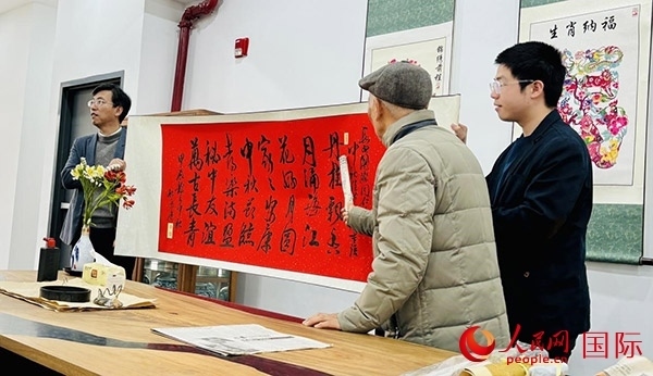 旅秘書法家向現(xiàn)場(chǎng)觀眾展示書法作品。人民網(wǎng)記者 宋亦然攝