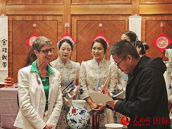 現(xiàn)場的非遺傳承人為英國觀眾展示畫技。人民網(wǎng)記者 邢雪攝