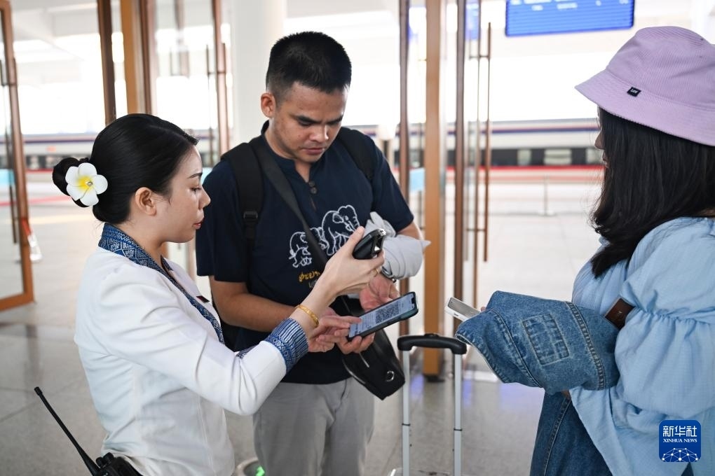 10月12日，在老撾萬象中老鐵路萬象站，工作人員檢驗乘客車票。新華社記者 程一恒 攝