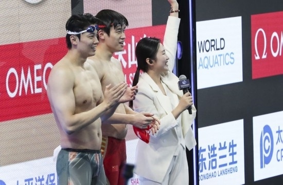  10月18日，汪順（左）和潘展樂在男子100米混合泳決賽后。新華社記者 方喆 攝