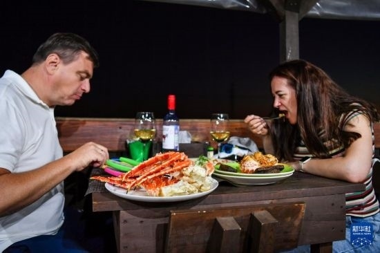 9月2日，食客們在俄羅斯符拉迪沃斯托克的一家餐館品嘗帝王蟹。新華社記者 曹陽 攝