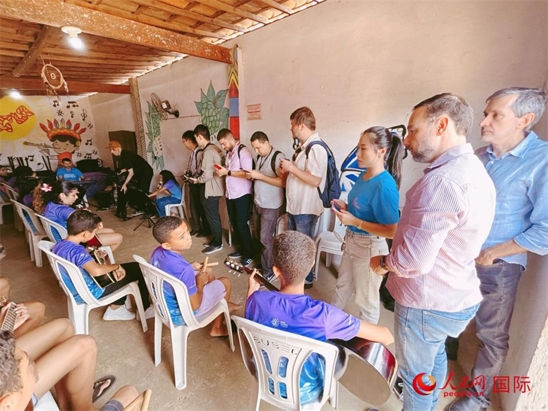  受益于中國企業(yè)的“青少年成長”項目，700多名當(dāng)?shù)厍嗌倌甑囊魳泛妥闱驂粝氩迳狭顺岚?。圖為聯(lián)合采訪團正在采訪參加音樂培訓(xùn)的孩子們。 人民網(wǎng)記者 陳一鳴攝