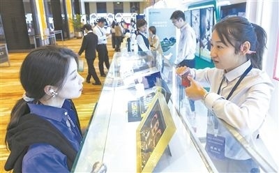 在北京麗澤商務區(qū)，工作人員（右一）介紹數(shù)字人民幣SIM卡硬錢包。新京報記者 陶冉攝